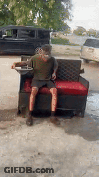 Man Sitting On Couch In Driveway With Van GIF