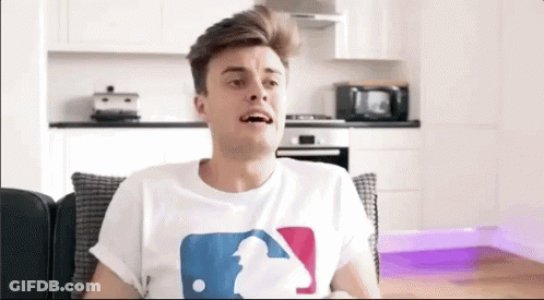 Man Sitting On Couch In White Baseball T-Shirt GIF