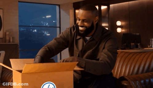 Man Sitting On Couch Opening Box With Blue Circle GIF