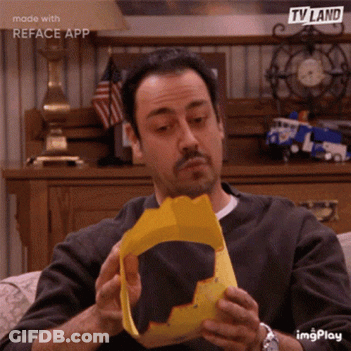 Man Sitting On Couch Reading TV Land Paper GIF