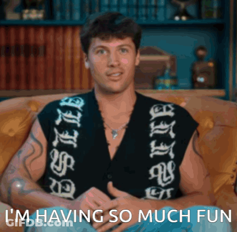 Man Sitting On Couch Saying I'm Having So Much Fun GIF