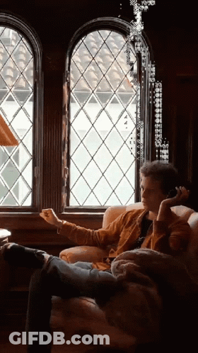 Man Sitting On Couch Talking On Cell Phone GIF