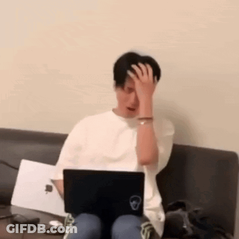 Man Sitting On Couch Using Laptop Holding His Head GIF