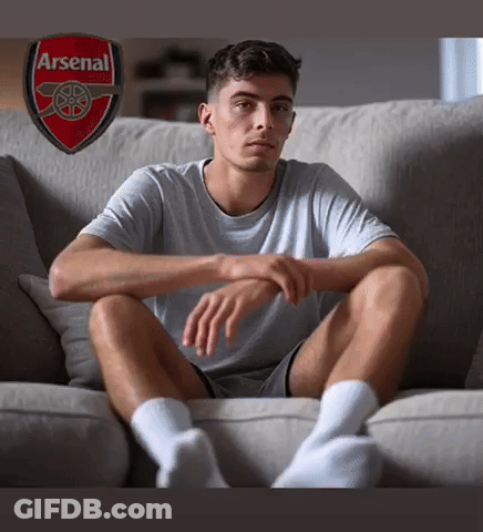 Man Sitting On Couch With Arsenal Logo GIF
