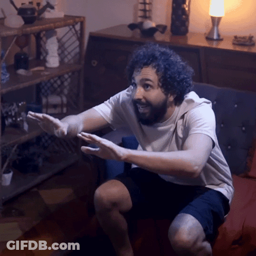 Man Sitting On Couch With Hands Outstretched GIF