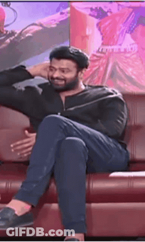 Man Sitting On Couch With Legs Crossed And Hand On Head GIF