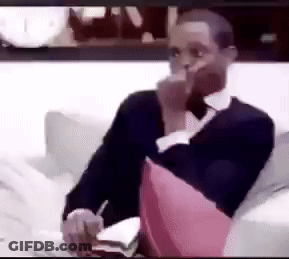 Man Sitting On Couch With Pink Pillow And Smoking GIF