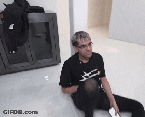 Man Sitting On Floor In Black Shirt Saying X GIF