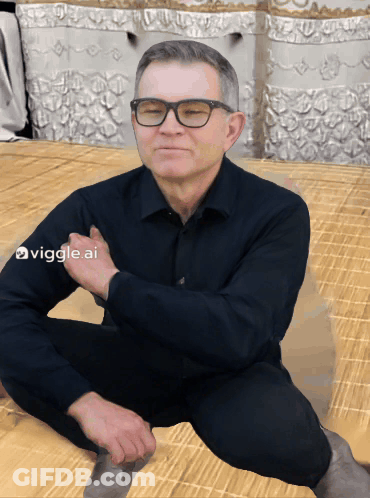 Man Sitting On Floor With Glasses And Black Shirt GIF