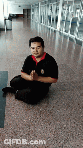 Man Sitting On Floor With Hands Folded GIF