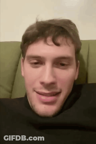 Man Sitting On Green Couch With Head In Black Turtleneck GIF