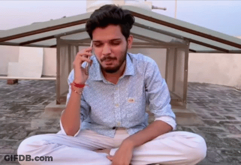 Man Sitting On Ground Talking On Cellphone GIF