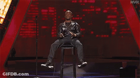 Man Sitting On Stage With Microphone GIF