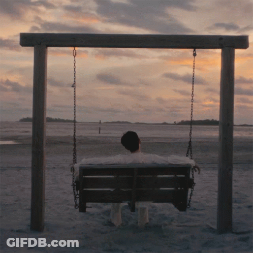 Man Sitting On Swing On Beach GIF