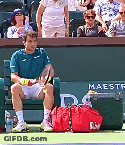 Man Sitting On Tennis Court Holding Racquet GIF