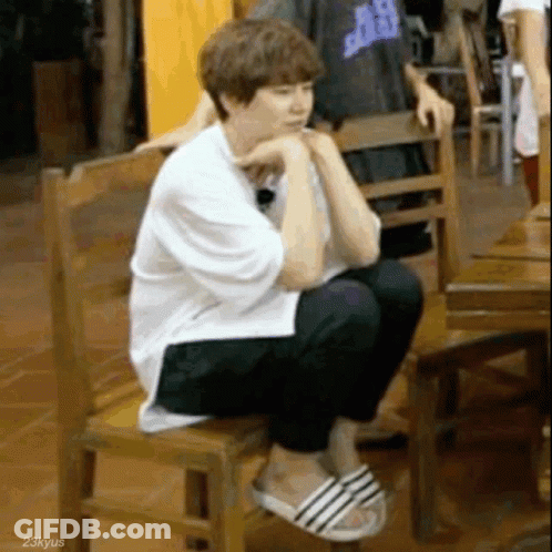 Man Sitting On Wooden Chair Wearing Sandals GIF