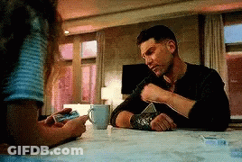 Man Sitting With Coffee And Woman Holding Phone GIF