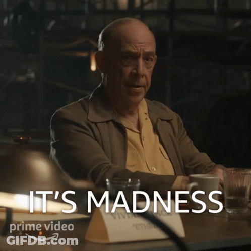 Man Sitting With Coffee Behind Madness GIF