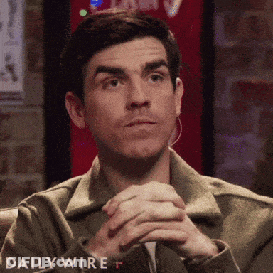 Man Sitting With Hands Folded In Front Of Daily Wire Sign GIF
