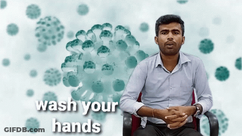 Man Sitting With Wash Your Hands Sign GIF