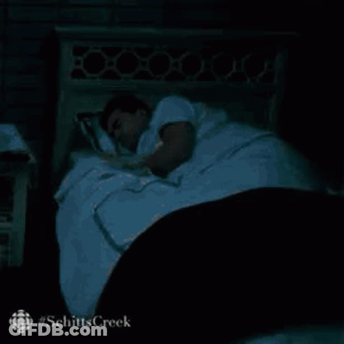 Man Sleeping In Bed With White Blanket And Black Comforter GIF
