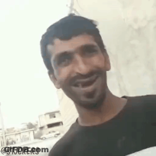 Man Smiling And Looking At Camera In Front Of Wall GIF