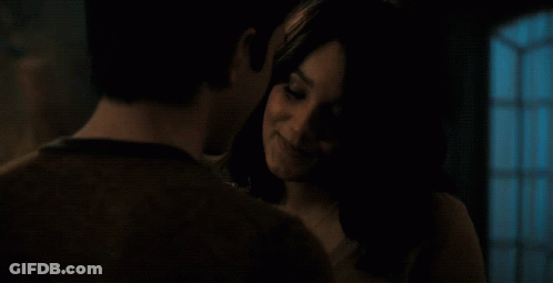 Man Smiling At Woman In Dark Room GIF