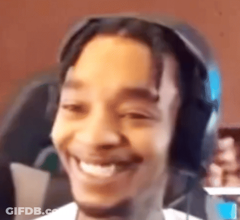 Man Smiling Holding Cell Phone With Headphones GIF