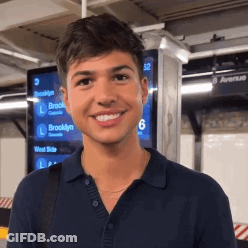 Man Smiling In Front Of 8 Avenue Sign GIF