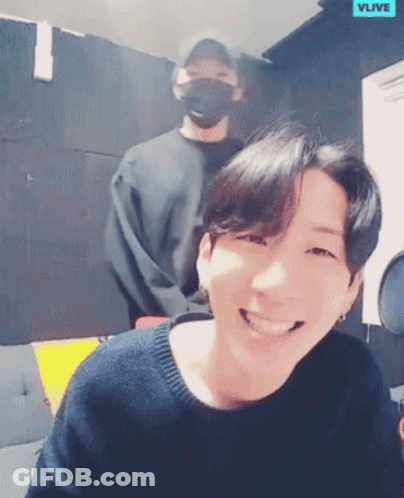 Man Smiling In Front Of Another Man Wearing Mask GIF