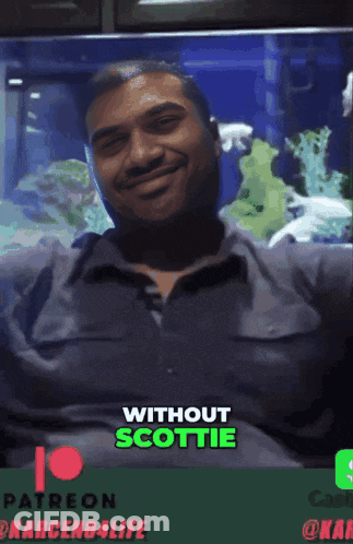 Man Smiling In Front Of Aquarium Without Scottie GIF