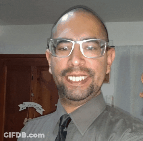 Man Smiling In Front Of Bienvenidos Sign GIF