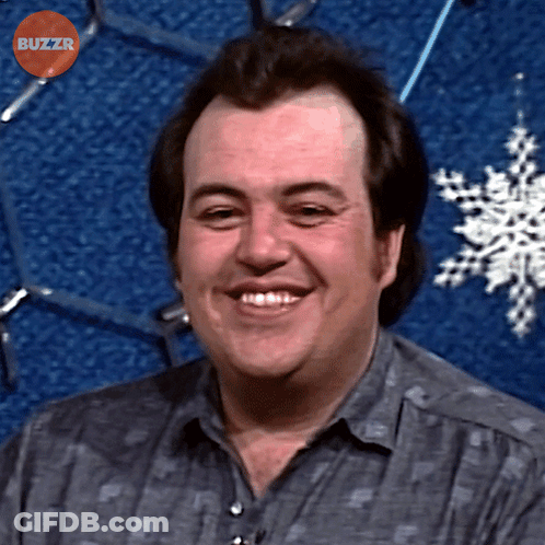 Man Smiling In Front Of Blue Background With Buzzr Text GIF