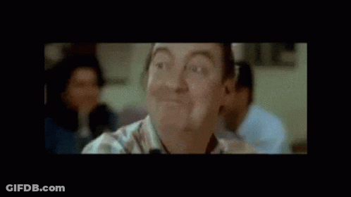 Man Smiling In Front Of Bravo Biloute Sign GIF