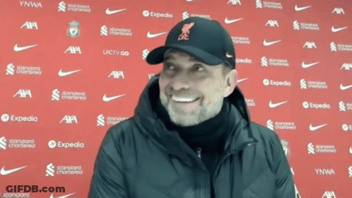 Man Smiling In Front Of Expedia Wall GIF