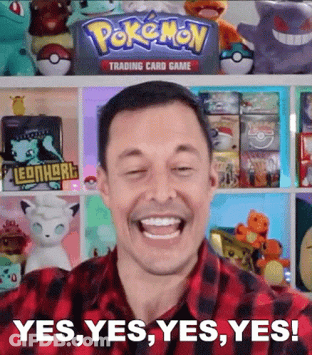 Man Smiling In Front Of Pokemon Trading Card Game Shelf GIF