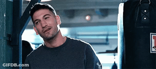 Man Smiling In Front Of Punching Bag GIF