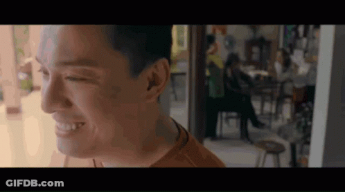 Man Smiling In Room With People At Tables GIF