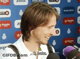 Man Smiling Talking Into Microphone Wearing Suspenders GIF