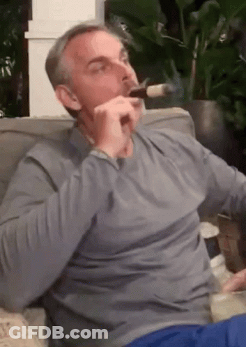 Man Smoking Cigar On Couch GIF