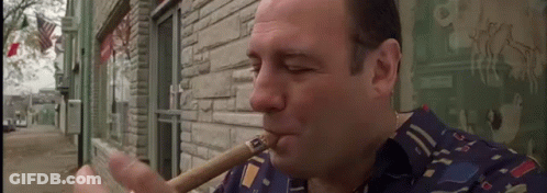 Man Smoking Cigar Outside Building GIF