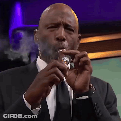Man Smoking Cigarette In Front Of Cravello20202 Sign GIF