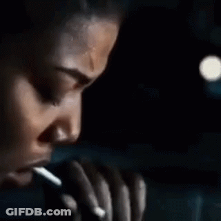 Man Smoking Cigarette In Front Of Pumpkin With Candle GIF