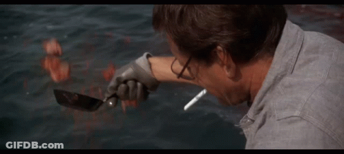 Man Smoking Cigarette In Front Of Shark In Ocean GIF