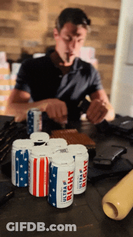 Man Smoking Cigarette In Front Of Six Ultra Light Beer Cans GIF
