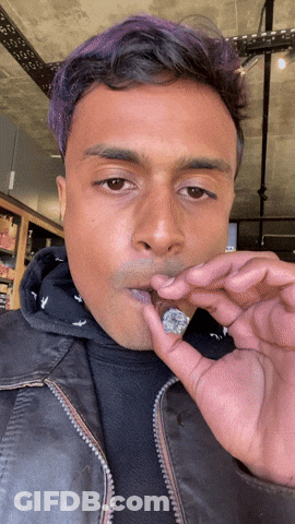 Man Smoking Cigarette In Parking Lot At Night GIF