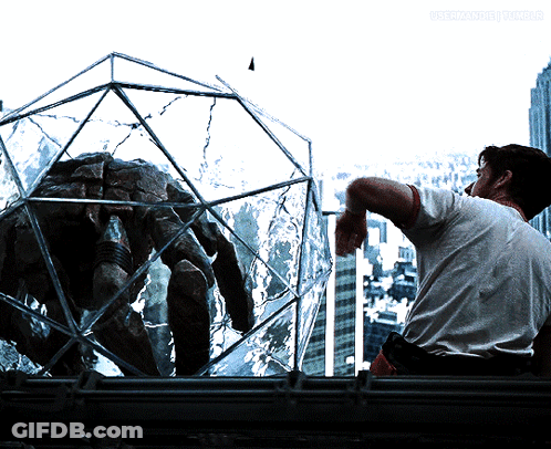 Man Smoking Cigarette Looking At Spider In Glass Cage GIF