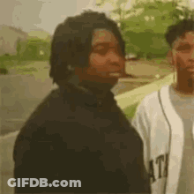 Man Smoking Cigarette Next To Baseball Player GIF
