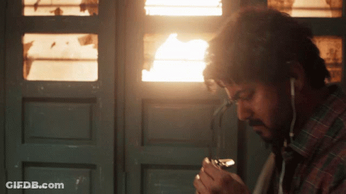 Man Smoking Cigarette With Ear Buds GIF