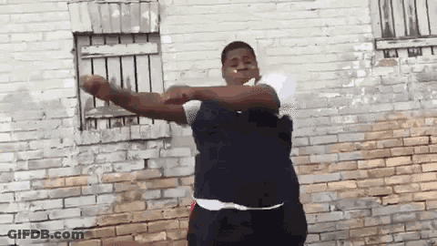 Man Smoking In Front Of Brick Wall GIF